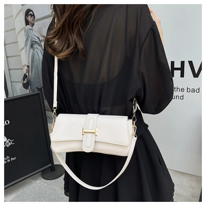Detail of white leather shoulder bag featuring a stylish golden buckle and slim strap