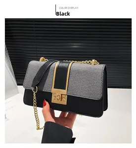Detail of black plaid crossbody bag featuring a gold metal chain and rotary lock