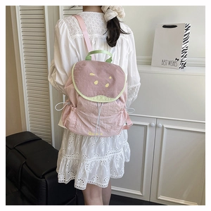 Detail view of pink watermelon themed backpack for kids with green trim and straps