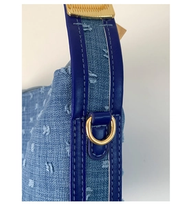 Detailaufnahme der blauen Denim-Umhängetasche mit Lederbesatz und Goldmetallbeschlägen
