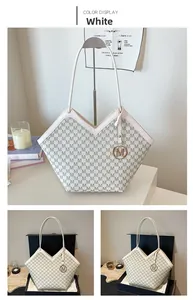 Detail of white tote bag with M-pattern print and gold M-pendant in gift packaging