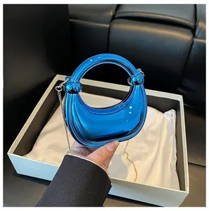 Detailed macro view of the translucent blue acrylic crescent bag with golden chain strap