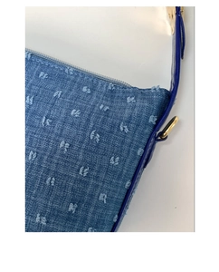 Nahaufnahme einer hellblauen Jeanstasche mit strukturierten Fransen-Punkten und Ring.