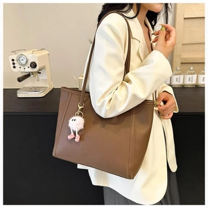 Klassische braune Shopper-Tasche aus mattem Leder mit einem süßen rosa Plüsch-Anhänger