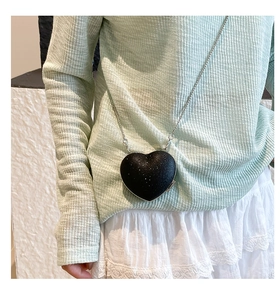 Dettaglio mini borsa a tracolla a forma di cuore nero glitterato con catena d'argento