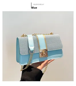 Detail of light blue crossbody bag featuring textured fabric and gold chain strap