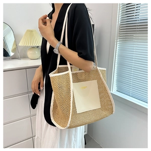 Detail of woven straw tote bag featuring white leather trim and luxury gold logo text
