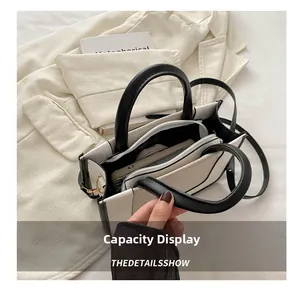 Spacious interior of black and white handbag showing multiple compartments and storage