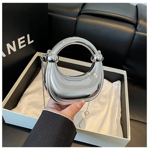 Close-up of silver mirror-effect acrylic box clutch with round handle and metal chain