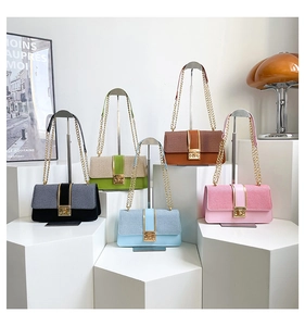 Detailed display of five color variant chain shoulder bags on geometric display stands