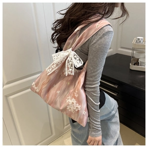 Close-up of pink gradient chiffon tote bag featuring white floral embroidery and lace bow