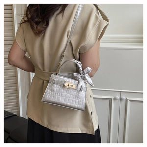 Silver crocodile texture bag with gold lock and silk scarf detail on a model