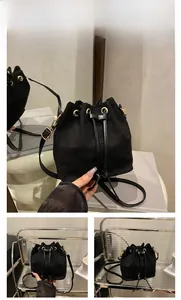 Close-up of black suede bucket bag showing drawstring closure and gold metal hardware detail