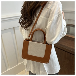 Brown and beige patchwork tote bag styled on white linen shirt for summer commute