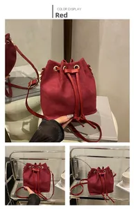 Detail view of red frosted leather bucket bag featuring drawstring and gold hardware