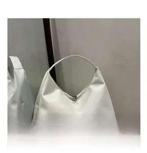 Detail view of white minimalist tote bag featuring smooth texture and metal double zippers