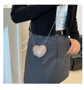 Dettaglio della borsa da sera a forma di cuore con glitter e tracolla a catena argento