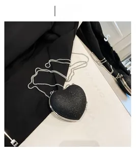 Detailed view of a heart-shaped evening clutch with black glitter and silver metal chain
