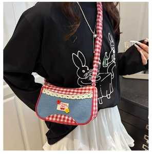 Detail of red checkered patchwork and floral button on a denim sweet shoulder bag