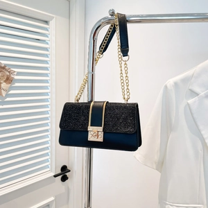 Chic black sequined crossbody bag with gold hardware and chain strap hanging on rack