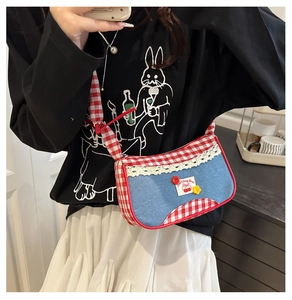 Detail of blue denim and red gingham crossbody bag with lace trim and floral accents