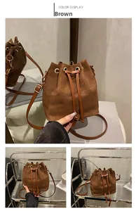 Close-up of brown matte suede bucket bag showing drawstring closure and metal eyelets