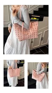 Pink faux leather tote bag with bear pattern shown on model in a modern interior setting