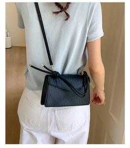 Vue arrière détaillée d'un petit sac à bandoulière noir chic à texture tissée