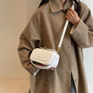 Minimalist white leather crossbody square bag with golden hardware on a model coat
