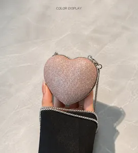 Dettaglio macro di una borsa da sera a forma di cuore con paillettes rosa chiaro