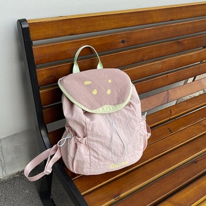 Pink fruit-themed backpack with Guava print on a wooden bench for casual travel