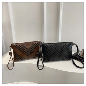Detailed close-up of rivet V-shaped pattern on stylish brown and black envelope bags
