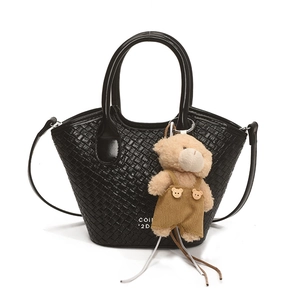 Chic black woven bucket bag with leather handle and cute plush bear charm accessory
