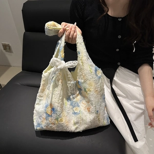 Tragetasche im chinesischen Stil mit Blumenstickerei und Spitzenschleife auf weißem Plüsch