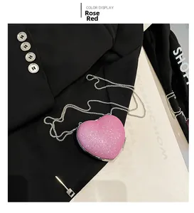 Detailed view of rose red heart-shaped evening bag with glitter surface and metal chain