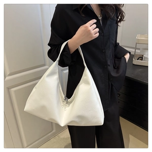 Detail of white PU leather hobo tote bag featuring minimalist triangular design and metal zippers