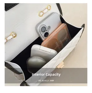 Detailed interior view of white quilted chain bag showing capacity for phone and cosmetics