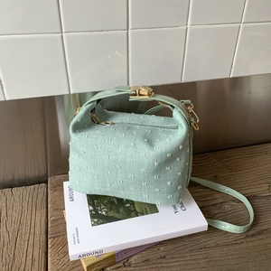 Detailed macro view of the mint green textured fabric on a stylish crossbody bag
