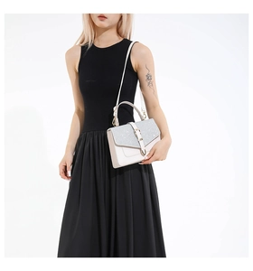 Détail du sac à main blanc avec rabat pailleté argenté et fermoir métal sur le modèle