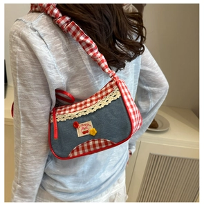 Detail of blue denim and red gingham shoulder bag with white lace and ruffles