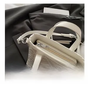 Detail view of smooth silver metal zipper and luxury geometric texture on bucket bag