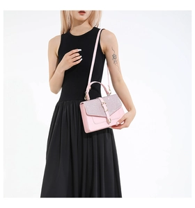 Sac bandoulière rose avec rabat pailleté et boucle dorée porté par un mannequin