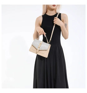 Detail of a beige handbag with silver sequined flap and decorative buckle for women