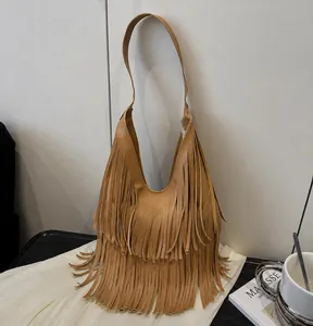 Close-up of tan fringe tote bag showing long tassel details and soft texture
