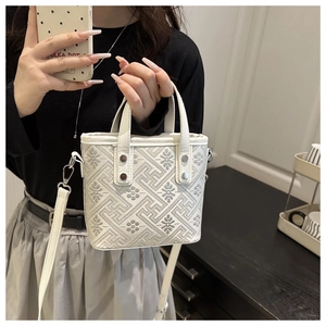 Detail view of white plaid jacquard bucket bag showing size on a shoulder strap