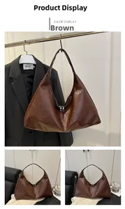 Close-up of brown oversized hobo bag showing matte leather texture and double zipper closure