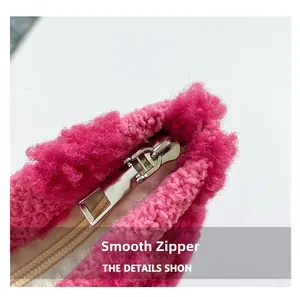 Detailopname van het gladde zilveren ritsdetail van dit roze pluche lippenstiftetui