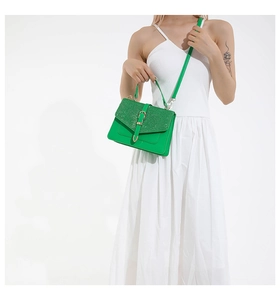 Detail of lime green handbag with gold buckle and glitter texture contrast on flap