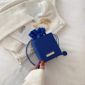 Royal blue mini bucket bag with satin drawstring and gold chain strap detail