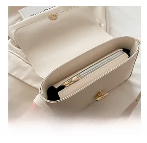Interior detail of creamy leather handbag showing smooth gold zipper and black lining